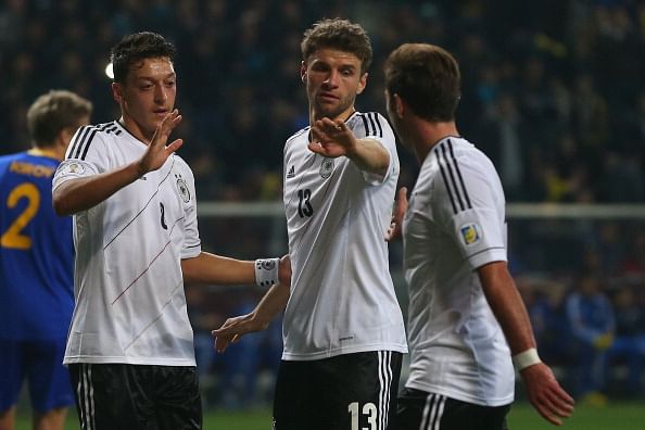 ASTANA, KAZAKHSTAN - MARCH 22: Thomas Mueller (C) of Germany celebrates scoring the 4th team goal with his team mates Mesut Oezil (L) and Mario Goetze (R) during the FIFA 2014 World Cup qualifier group C match between Kazakhstan and Germany